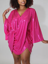 Close-up of a woman in a shimmering pink dress with ruched detailing and an asymmetrical hem.