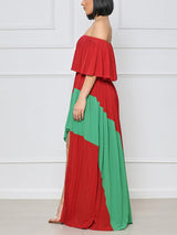 Side view of a woman wearing a red and green colorblock maxi dress.