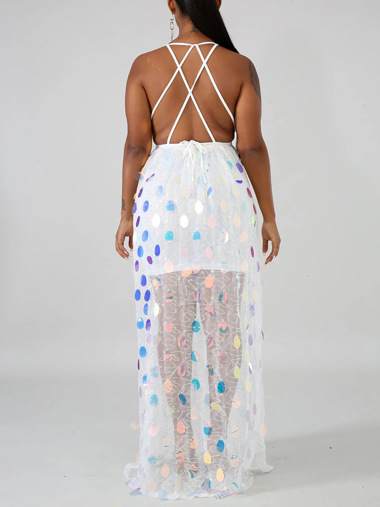 Back view of a woman wearing a white sequined maxi dress with an open back and criss-cross straps.