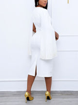 Back view of a woman in a white knee-length dress with cape sleeves and a square neckline.