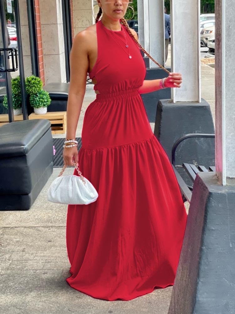 Side view of a woman in a red halter neck maxi dress with an elasticated waist and tiered skirt.