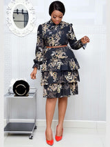 woman in a black paisley print tiered dress and red heels
