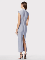 Back view of a model wearing a light blue sleeveless bodycon maxi dress with cut-out detail at the bust and high neckline, standing against a white background.