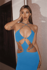 Woman posing in a blue knit midi dress with cut-out details and ring accents