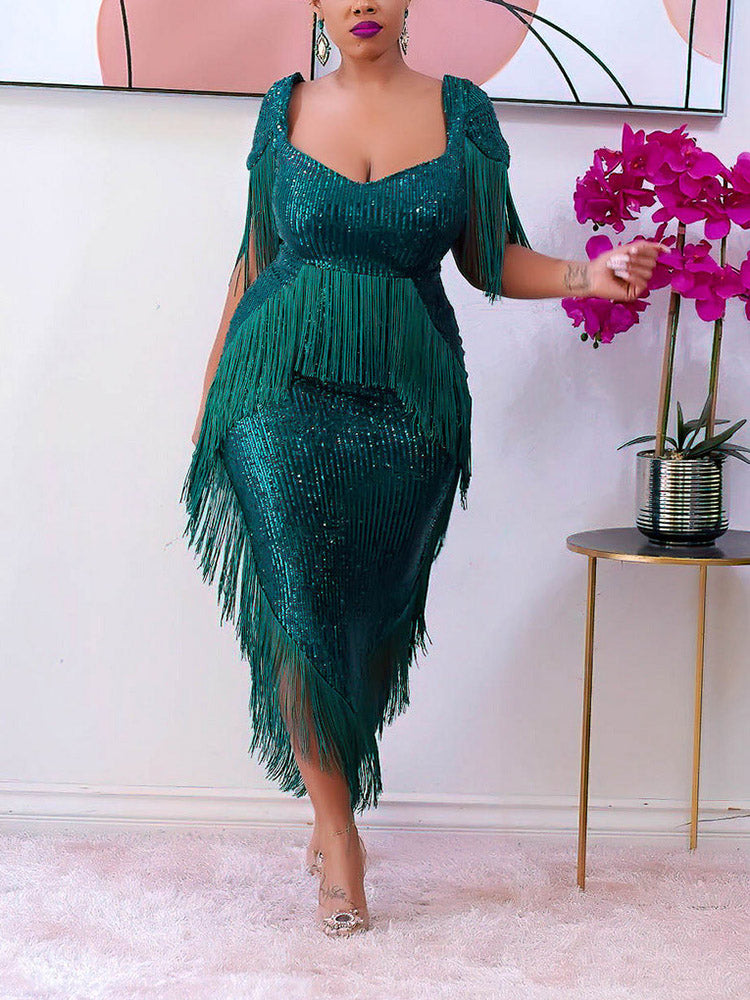 Woman wearing a green sequined dress with fringe detailing and a sweetheart neckline.