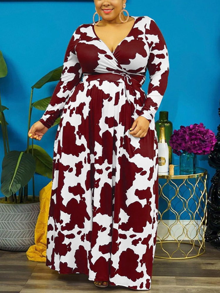 Woman wearing a burgundy and white cow print maxi dress with long sleeves and a surplice neckline.
