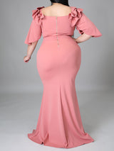 Side view of a woman showcasing the silhouette of a pink mermaid dress