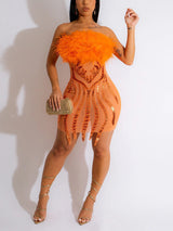 Woman wearing an orange strapless mini dress with feather trim and sequin details.