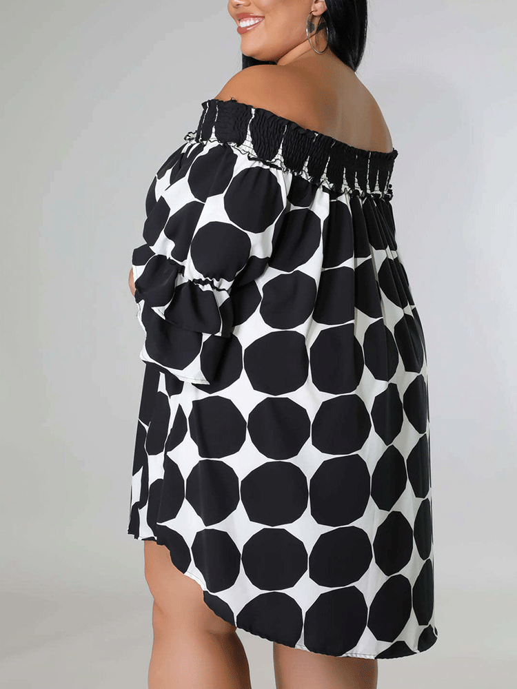 Back view of a woman in a black and white polka dot off-the-shoulder dress.