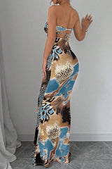 Back view of a woman in a strapless abstract print maxi dress.