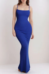 Woman in a long royal blue ribbed knit dress with thin straps.