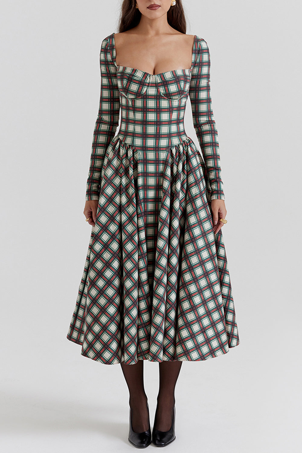 Woman wearing a long-sleeved midi dress with a plaid print and sweetheart neckline.