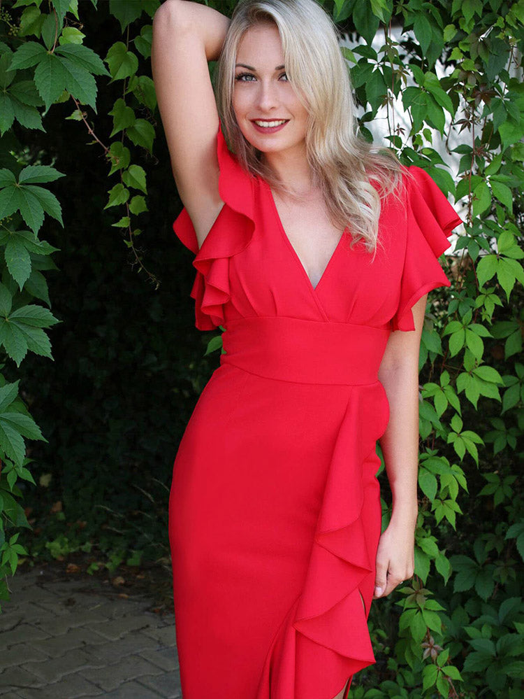 woman in a red sheath dress with ruffle details and a side slit