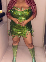 Plus-size woman wearing a green sequined mini dress with leaf appliques, red curly wig, and green sequined boots.