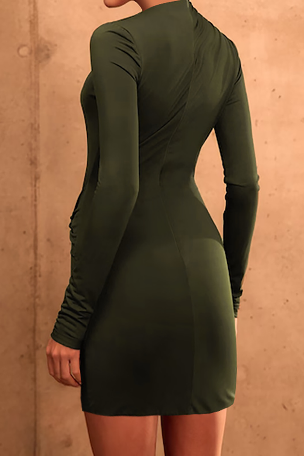 Back view of a woman in a fitted, long-sleeved olive green mini dress.