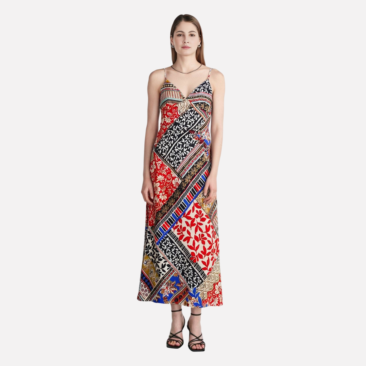 Woman wearing a colorful patchwork print maxi dress with spaghetti straps.
