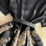 Detail of the belted waist on a black and floral print dress