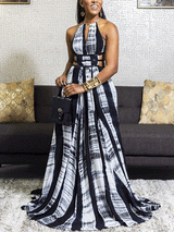 Front view of a woman modeling a black and white tie-dye maxi dress with a halter neckline and empire waist.