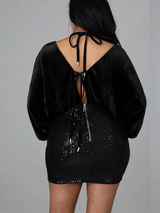 Rear view of a black velvet and sequin mini dress showing tie closure