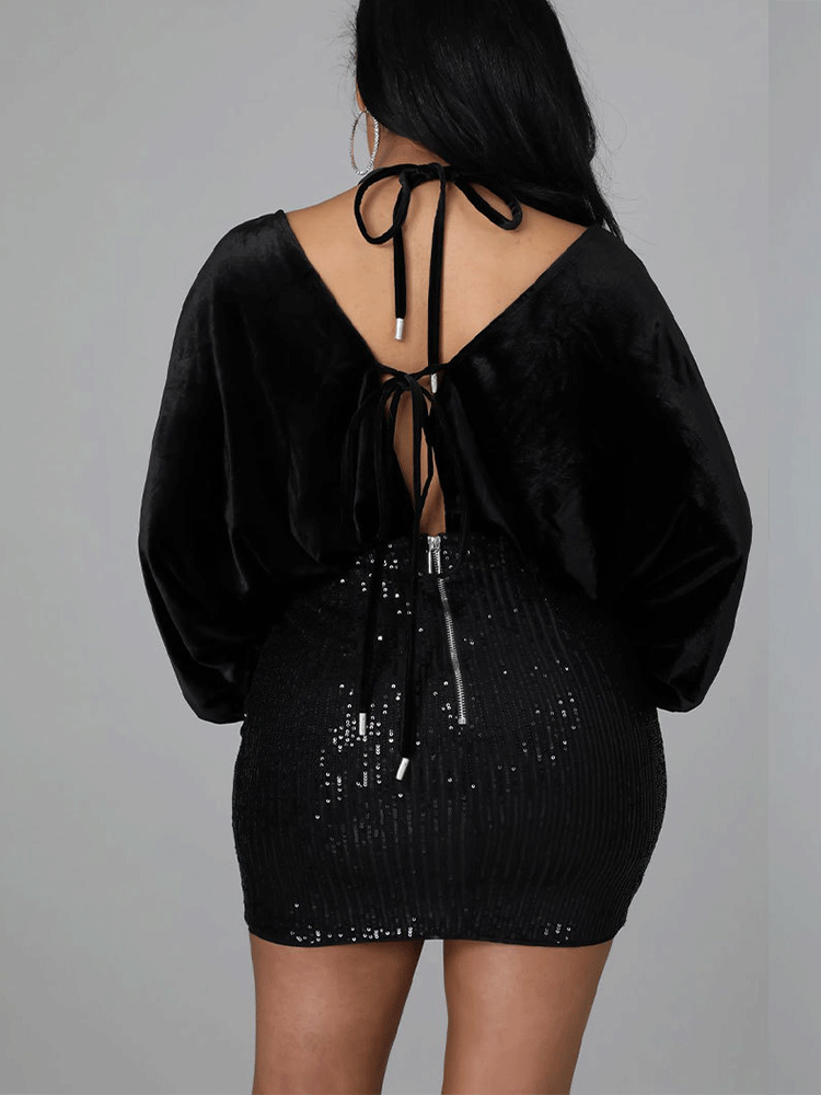 Rear view of a black velvet and sequin mini dress showing tie closure