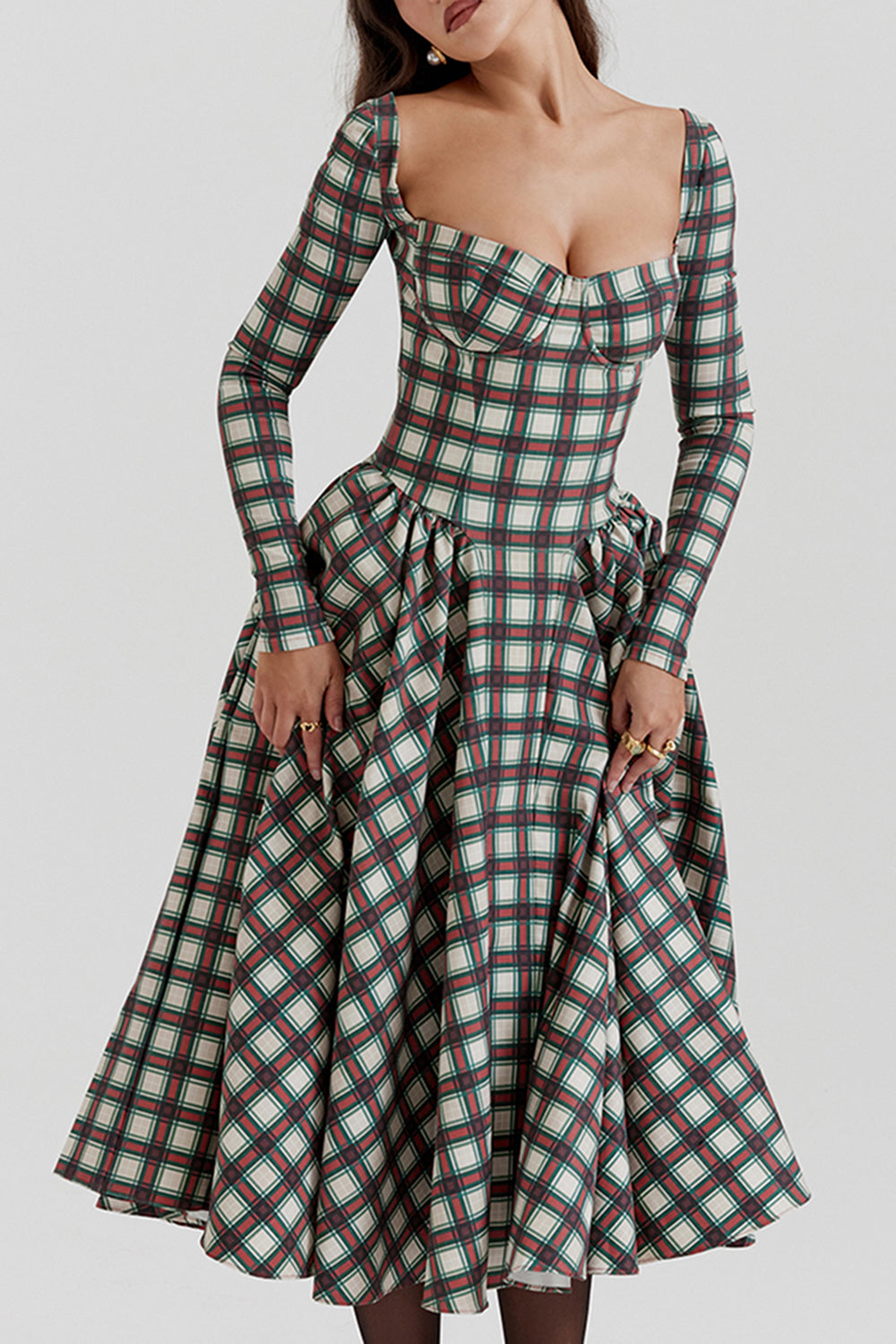 Close-up of a woman wearing a plaid midi dress with a sweetheart neckline and long sleeves.