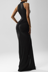 woman in a black halter neck gown with ruching and a high slit, back view