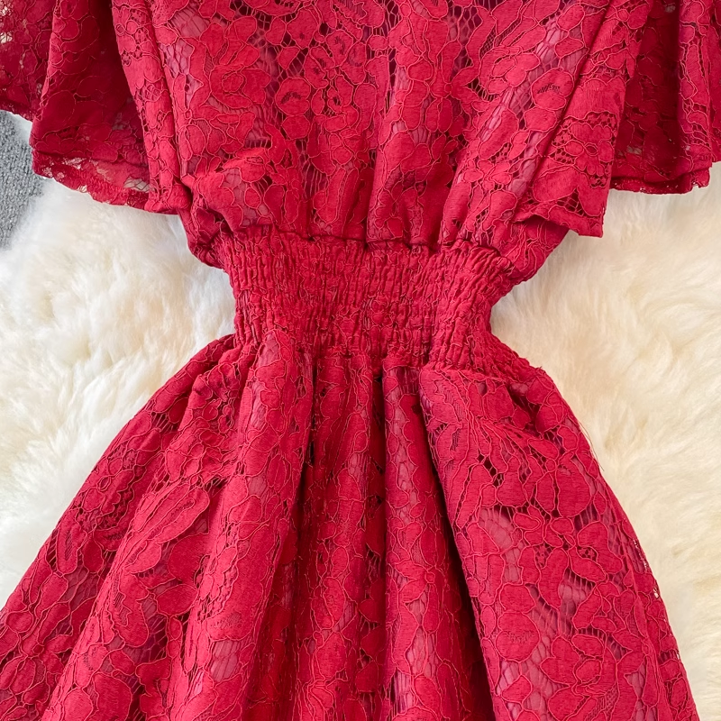 Close-up of the red lace dress, focusing on the elasticized waistband and the flared skirt.
