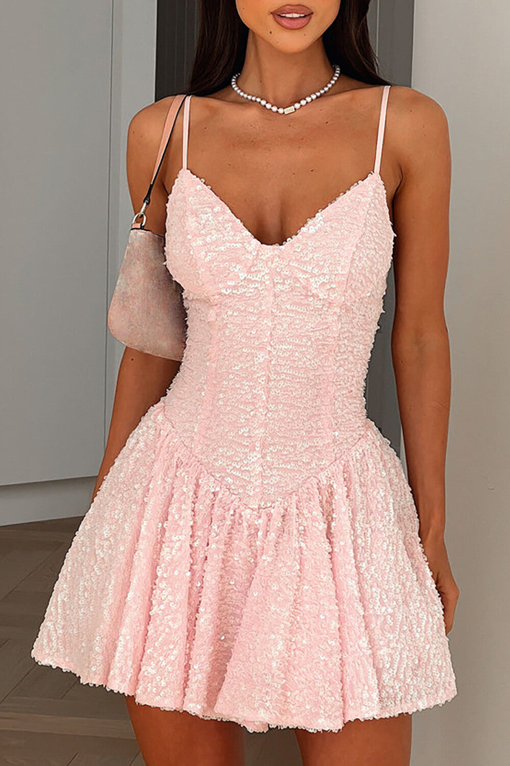 Close-up of a woman in a pink sequined party dress.