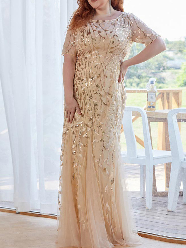 Full-length view of a woman in a gold sequined formal dress.