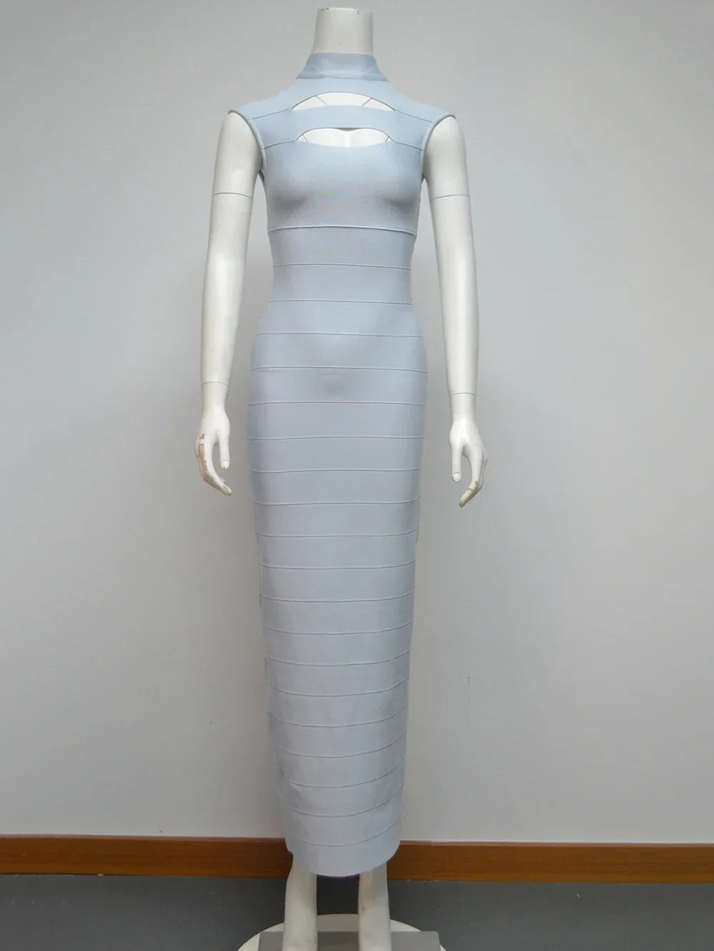 Light blue sleeveless bodycon maxi dress with cut-out detail at the bust and high neckline displayed on a mannequin against a white background.