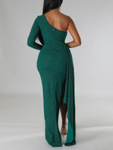 Back view of a green one-shoulder formal dress with a zipper closure and flowing skirt