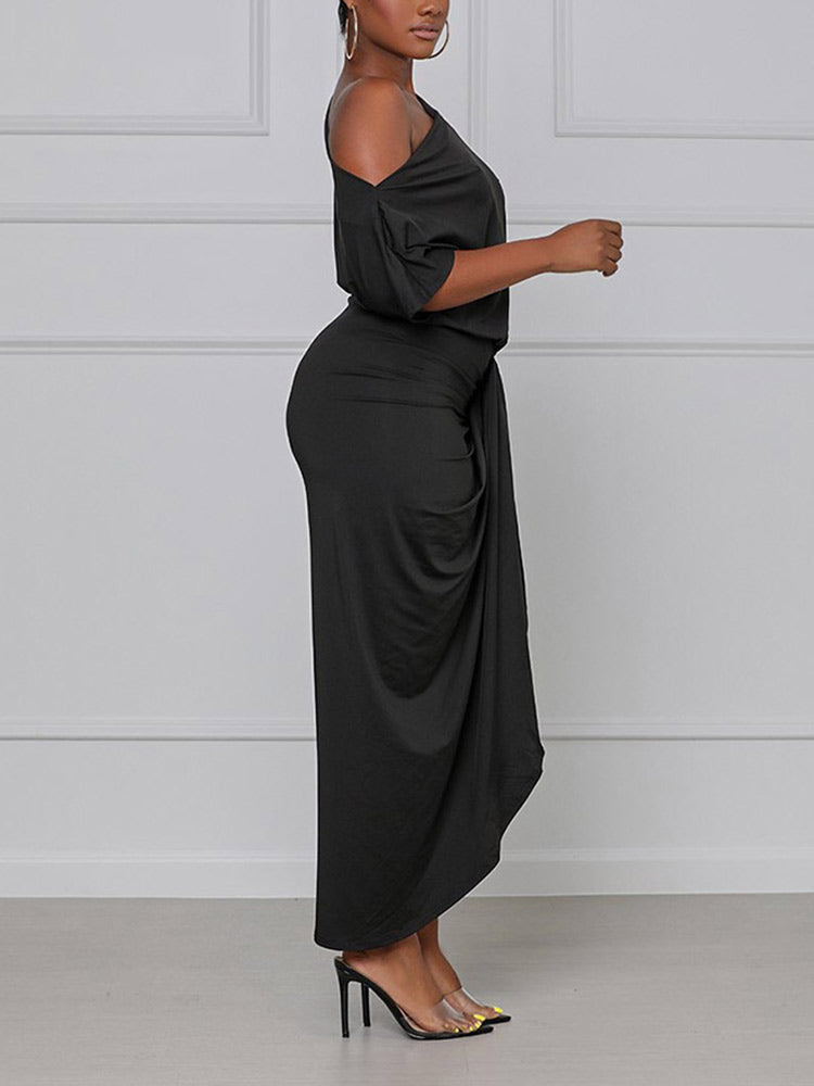 side view of a woman in a black one-shoulder draped dress
