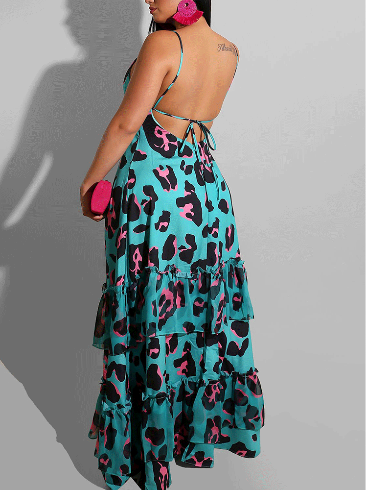 Back view of a woman wearing a turquoise maxi dress with a black and pink leopard print, showcasing an open back with tie closure and a tiered, ruffled skirt.