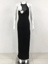 black floor-length halter dress with white floral embellishments displayed on a mannequin