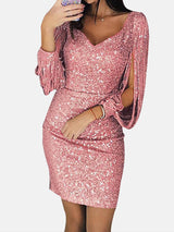 Woman wearing a pink sequin dress with tassel sleeves