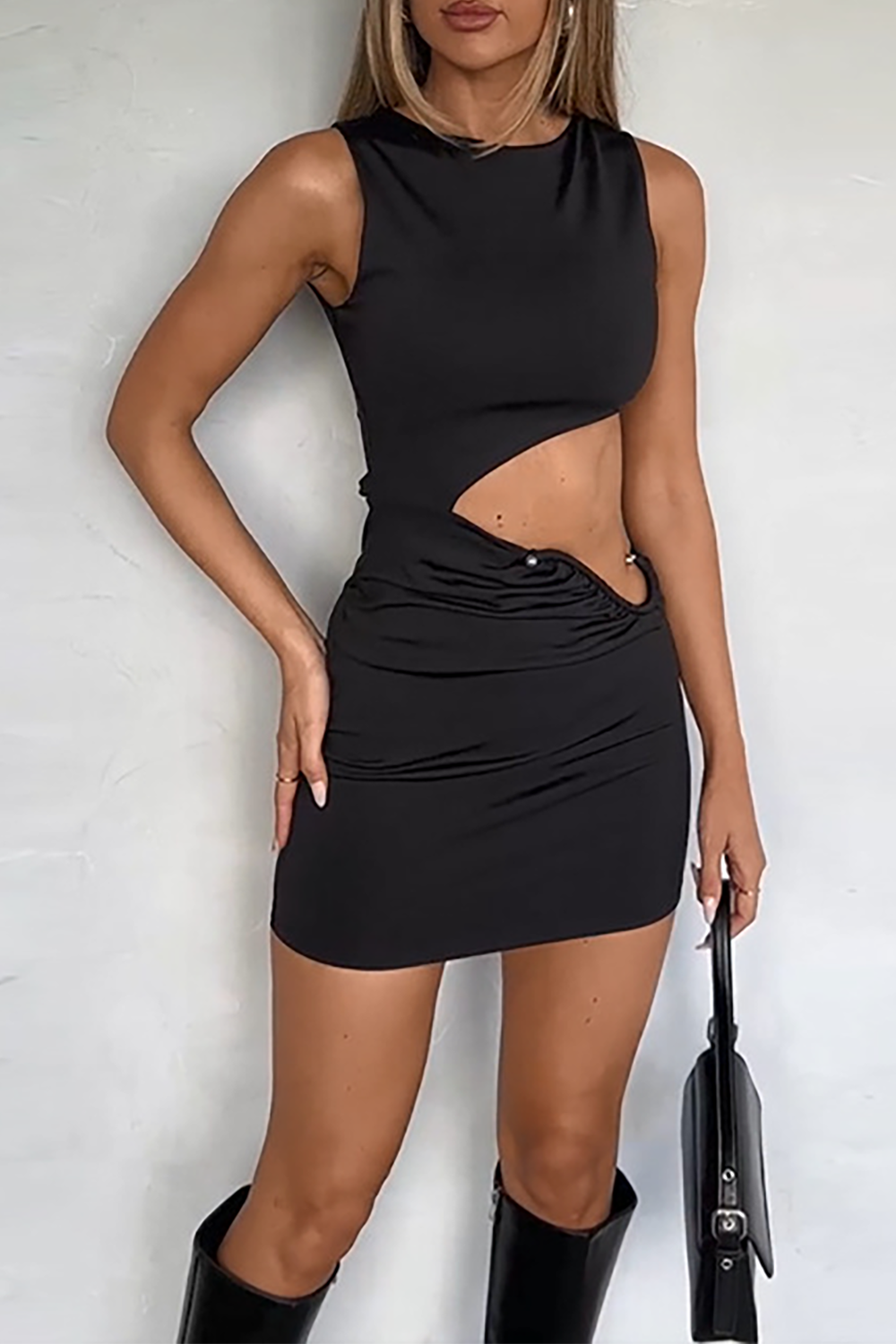 Front view of a woman modeling a black cut-out mini dress.