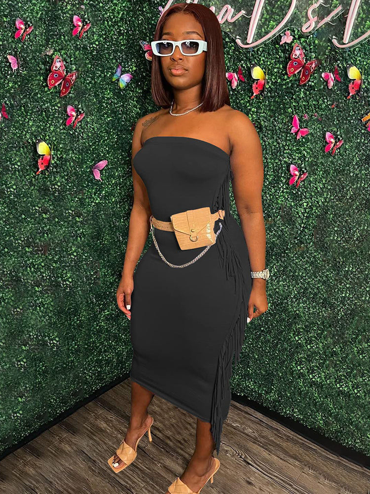 Woman wearing a black strapless midi dress with fringe trim and a beige fanny pack, paired with beige heels.