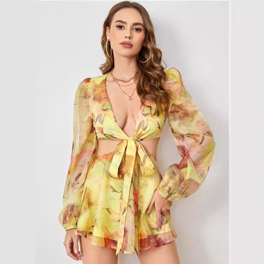 Woman wearing a yellow and floral print two-piece set with a deep V-neck, front tie, and cut-out detail.