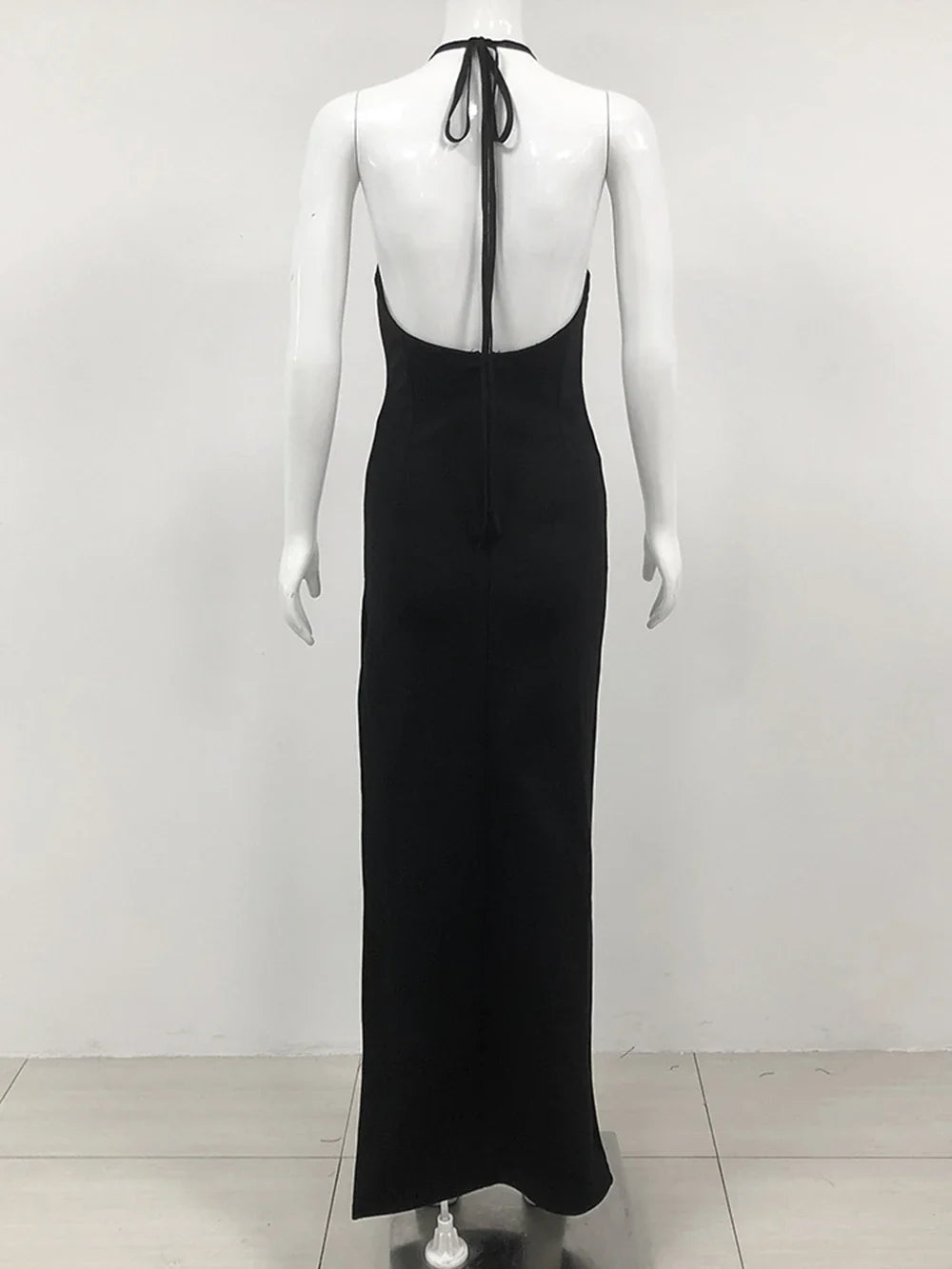 back view of a black floor-length halter dress with an open back and halter straps displayed on a mannequin