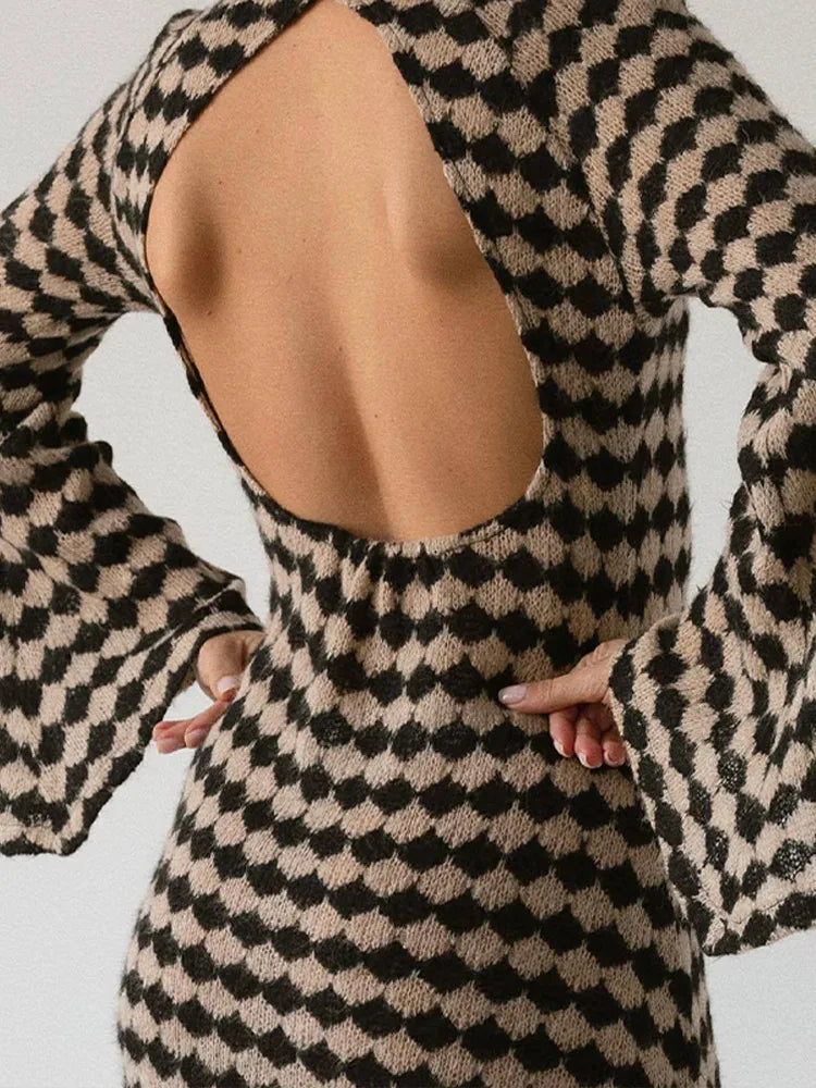 Close-up of the back of a knit dress with an open back and a black and beige geometric diamond pattern.