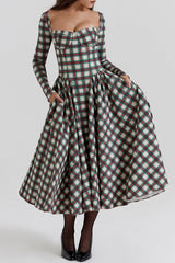 Woman in a plaid midi dress with pockets, showing the full skirt.
