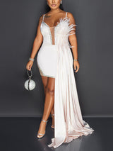 Woman wearing a white mini dress with a feathered shoulder and a long train.