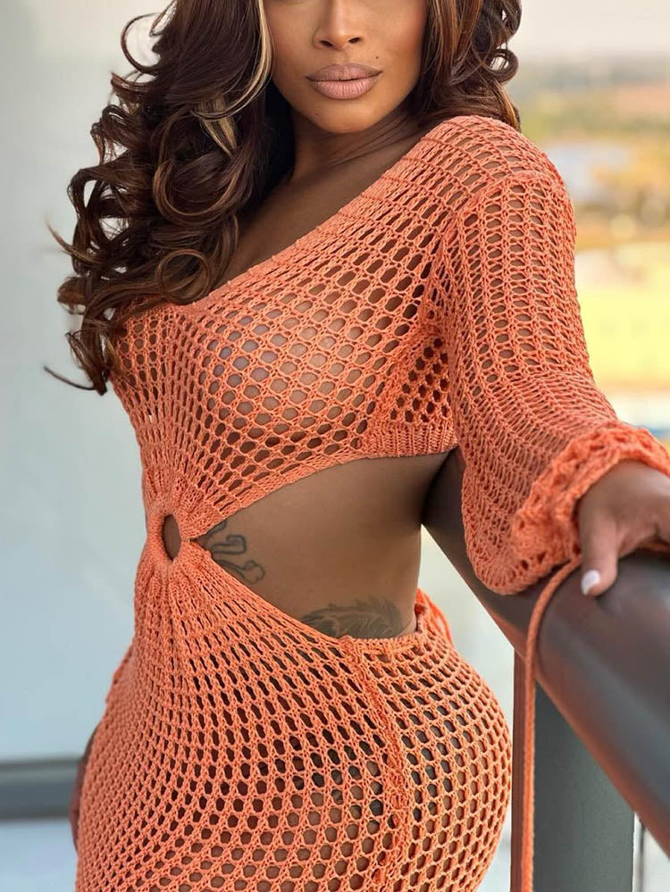 Woman wearing an orange crocheted maxi dress with a V-neckline and flowing sleeves.