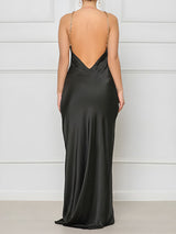 back view of a woman in a black satin slip dress with a deep V-back