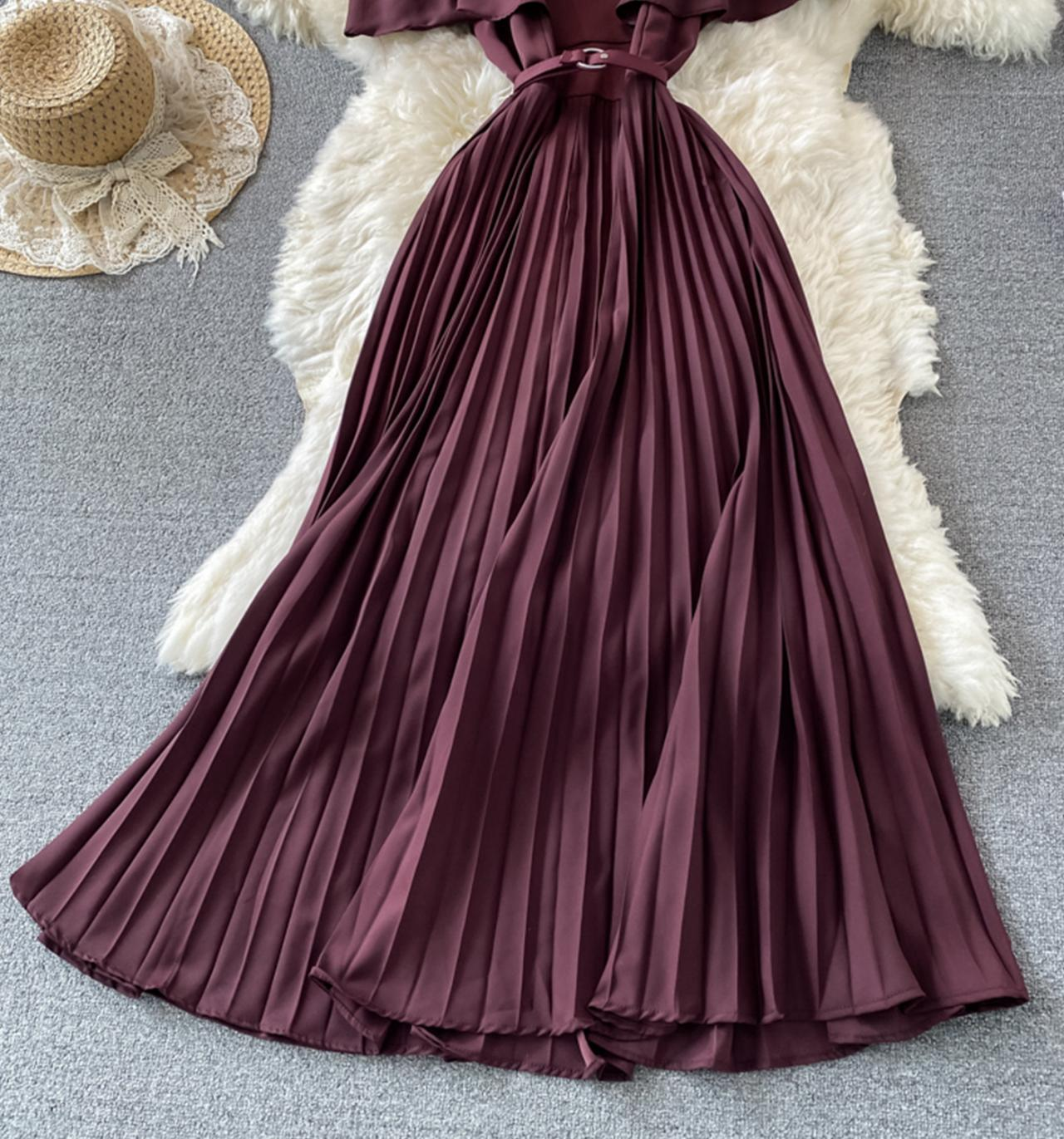Full view of the pleated skirt of a burgundy dress