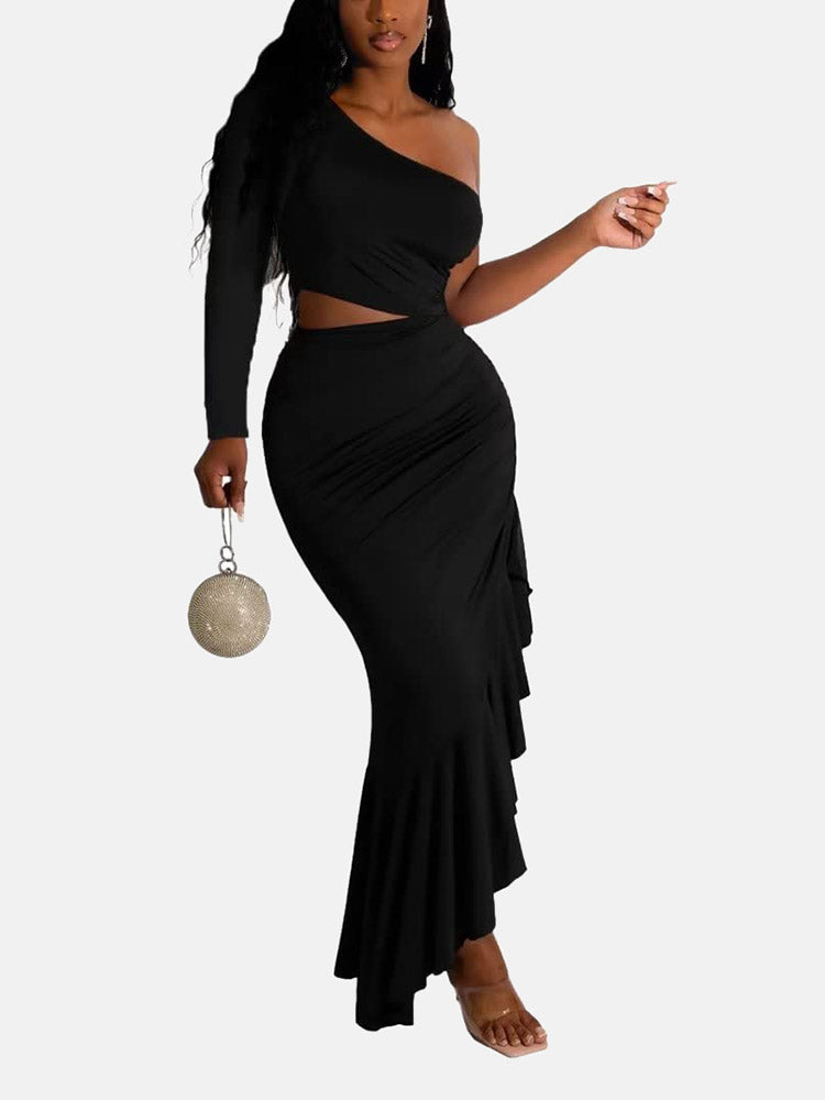 Woman wearing a black one-shoulder, long-sleeved maxi dress with a cut-out waist and ruffled asymmetrical hem, holding a round metallic clutch.