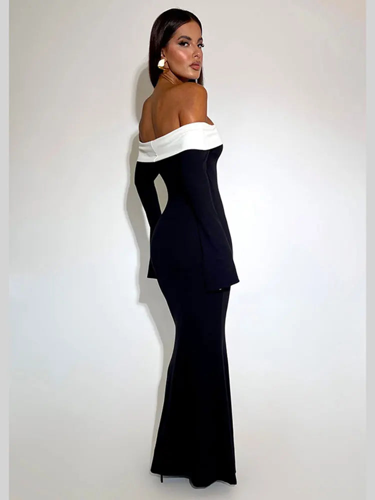 Back view of a woman in a black off-the-shoulder floor-length dress with a white trim.
