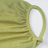 Close-up of the textured fabric of a lime green mask with ruched detailing and a loop for the ear.