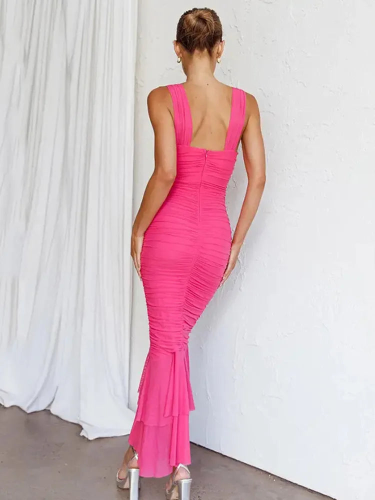 Back view of a woman in a bright pink ruched mesh gown.