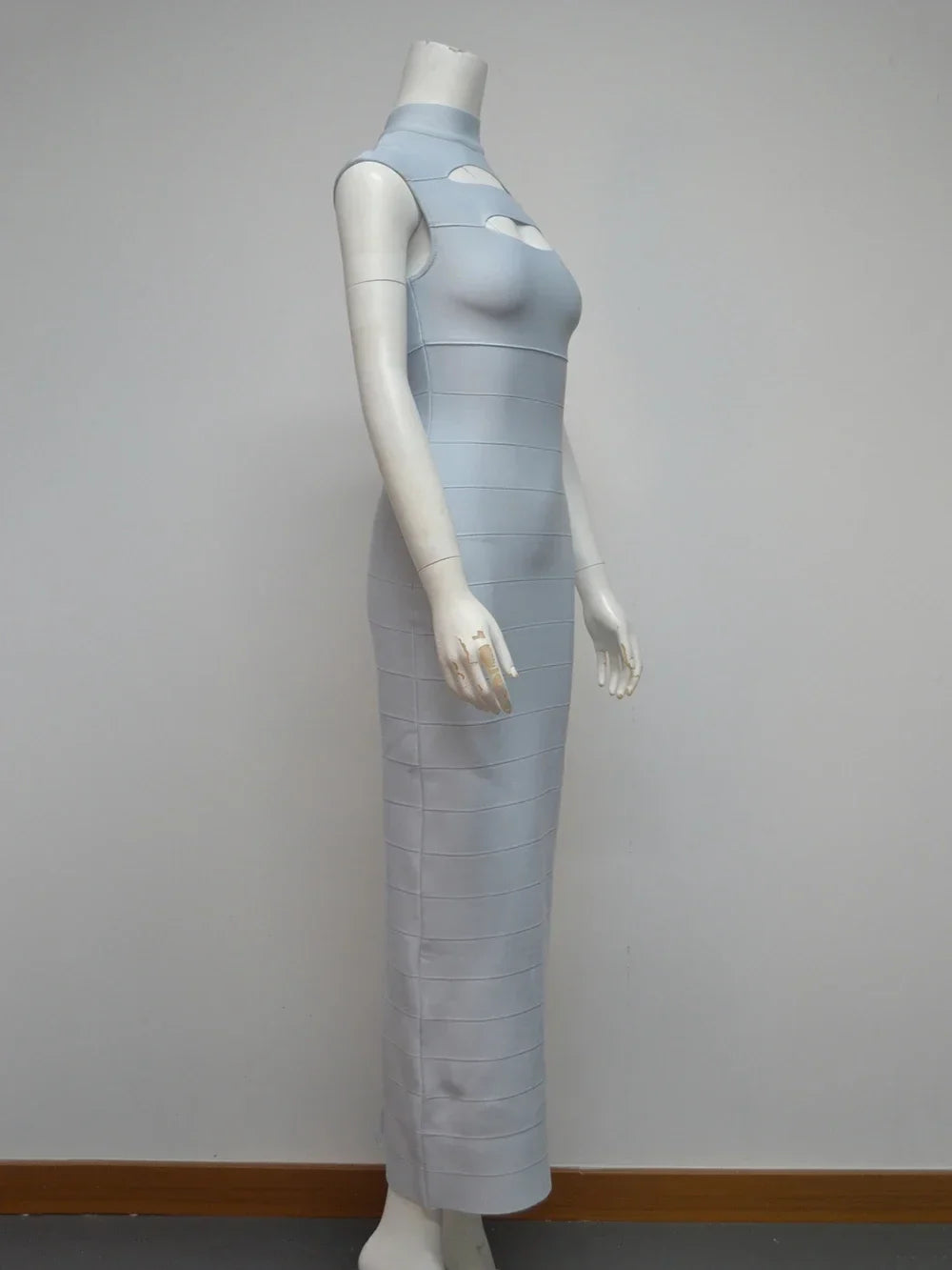 Side view of a light blue sleeveless bodycon maxi dress with cut-out detail at the bust and high neckline displayed on a mannequin against a white background.